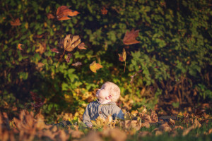 baby boy with falling leaves